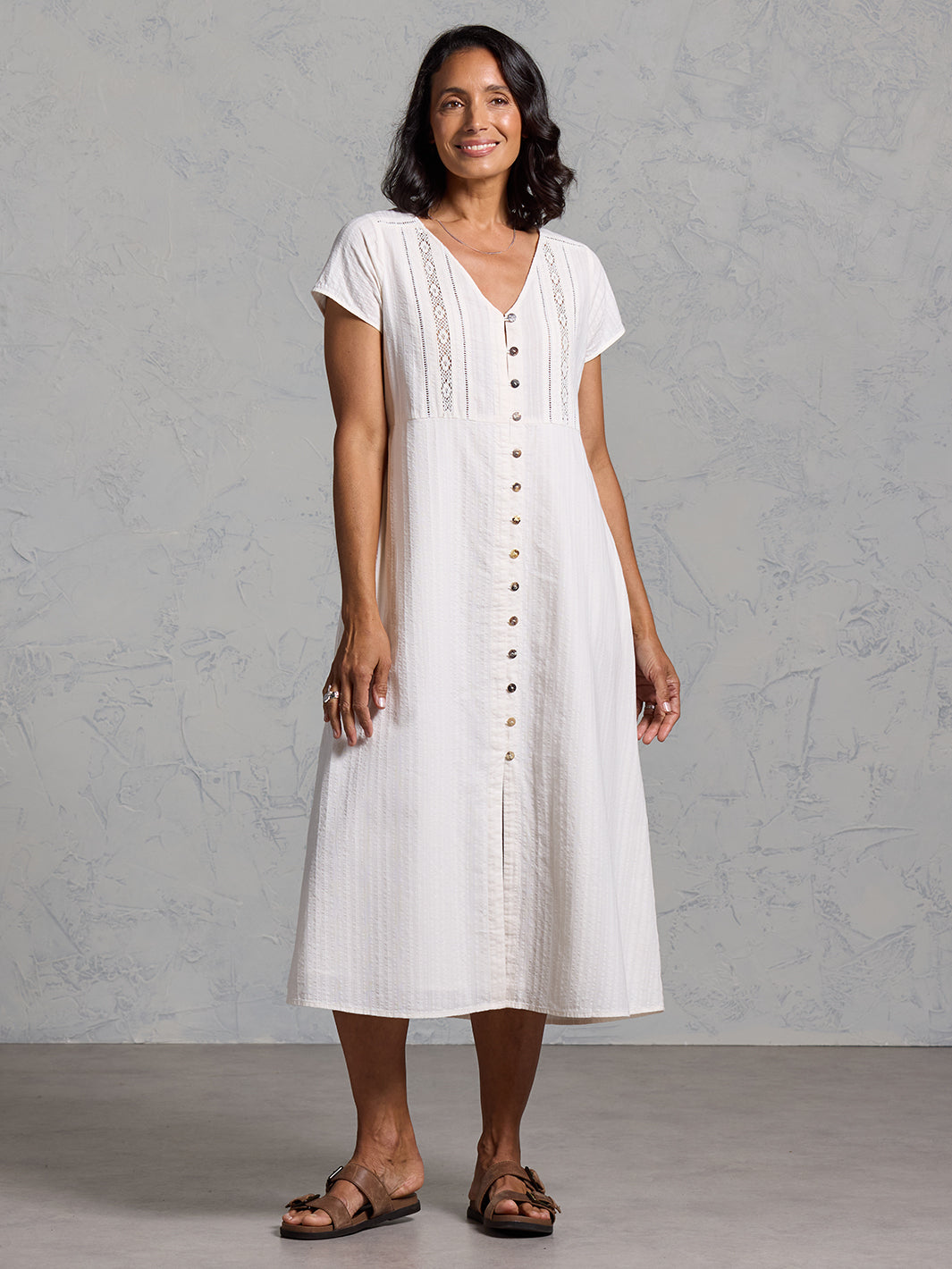 A woman wearing a cotton dress in coconut from Nomad the Label
