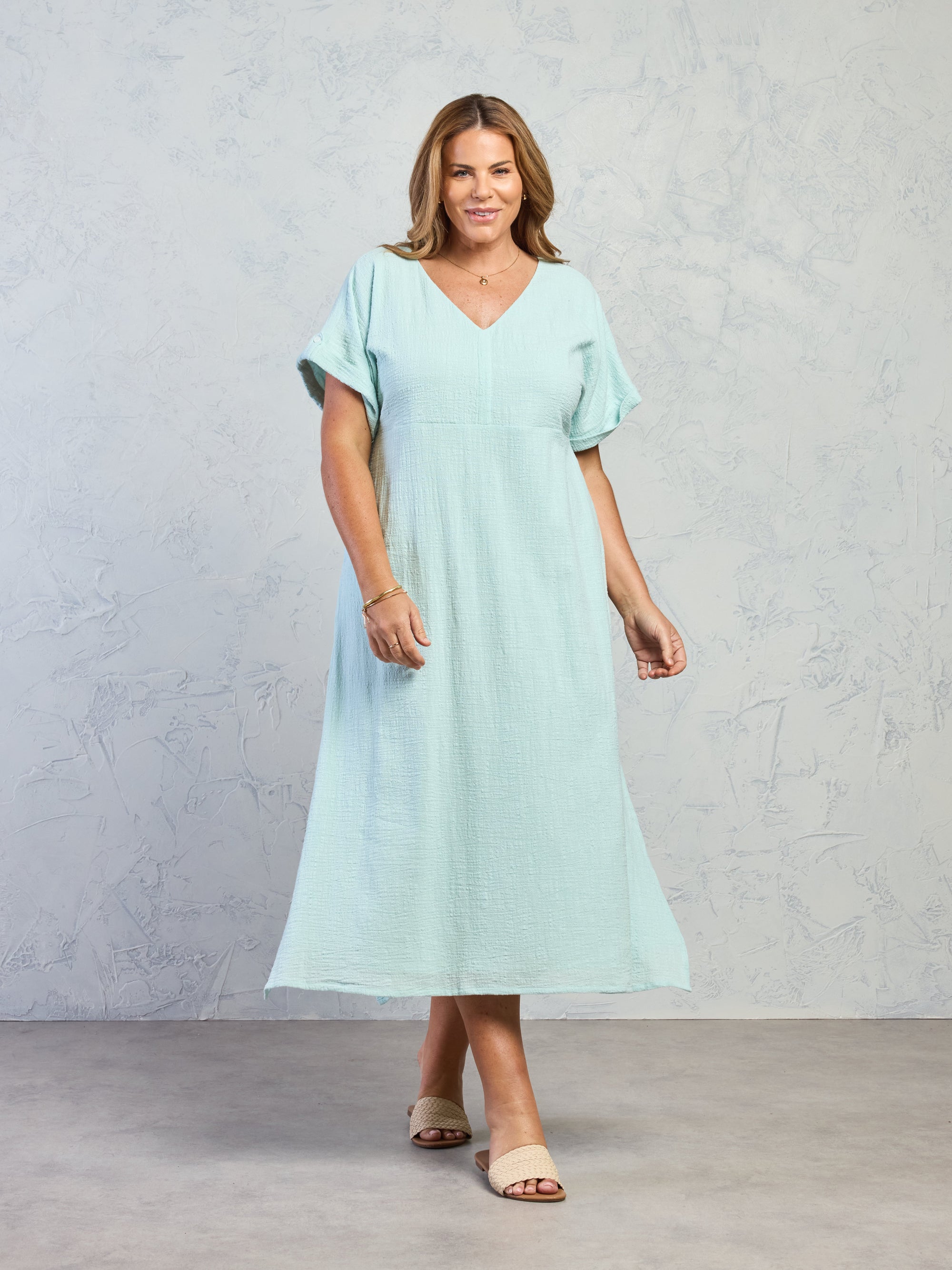 Woman wearing a light blue dress against a plain background