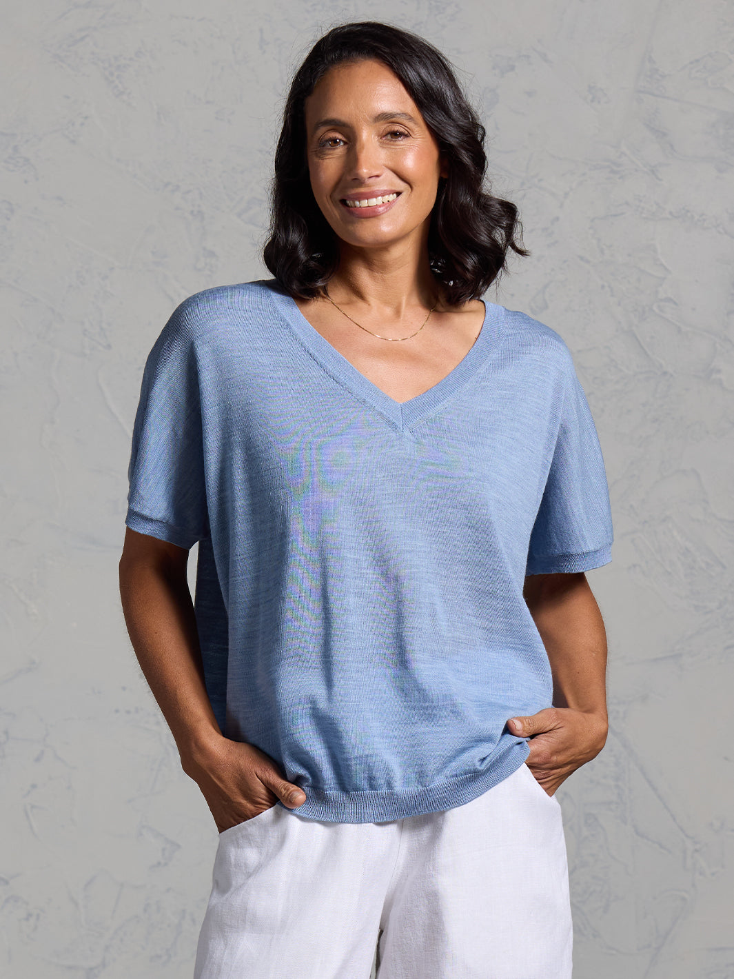 A woman wearing Toscana Merino Wool Top Sea Blue and Sadhu French Linen Pants White
