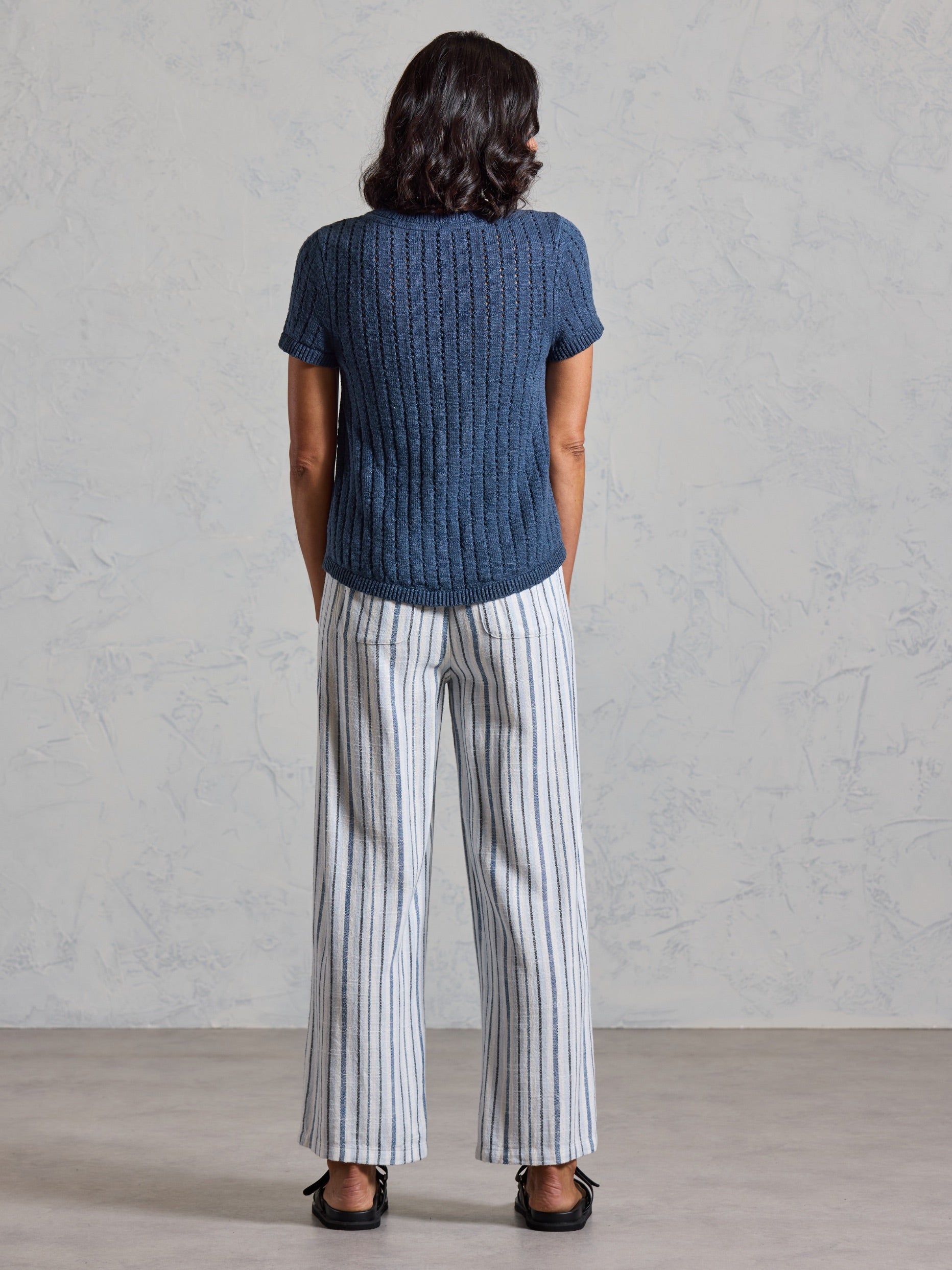 Back view of the Agni Cotton Linen Knit Top in navy showing the textured pointelle knit and ribbed hem.