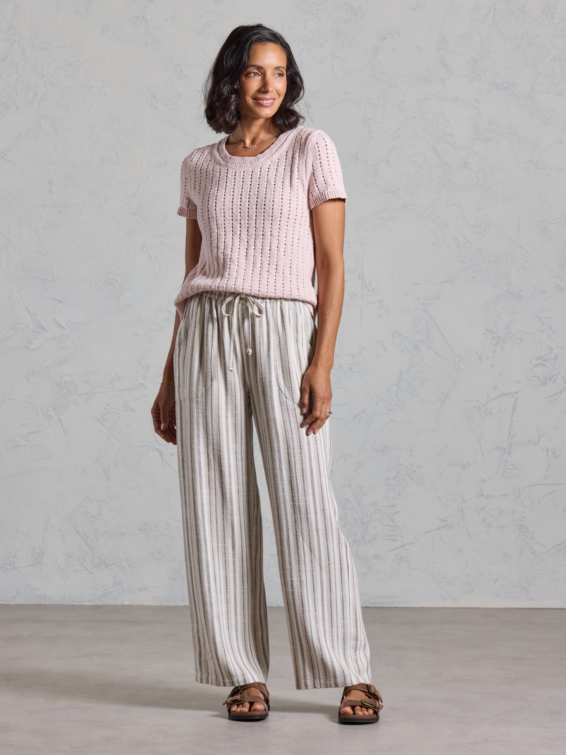 Full length view of the Jolie Linen Blend Trousers in driftwood, paired with a pink knit top.