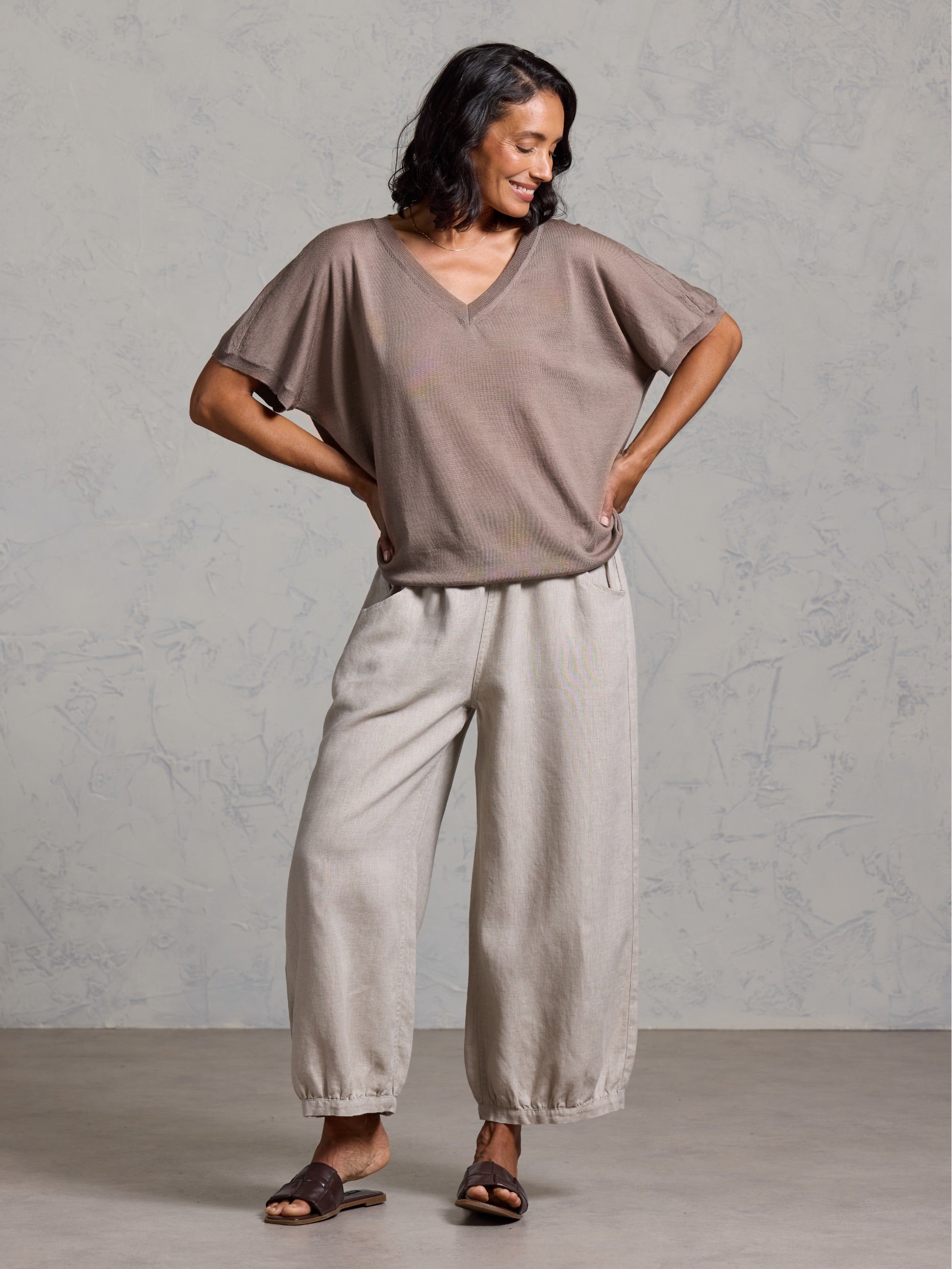 A woman wearing Toscana Merino Wool Top Elm and Sadhu French Linen Pants Flax