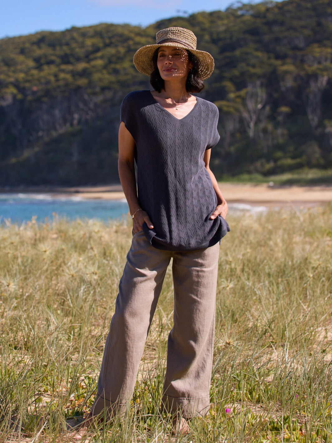 Woman standing in a grassy field with a scenic background