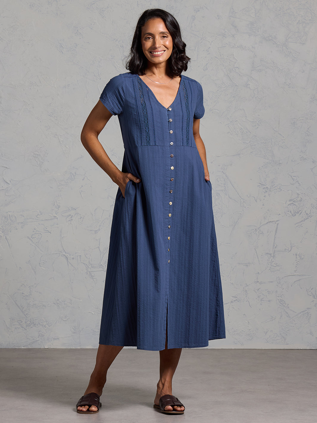 A woman wearing a cotton dress in navy from Nomad the Label