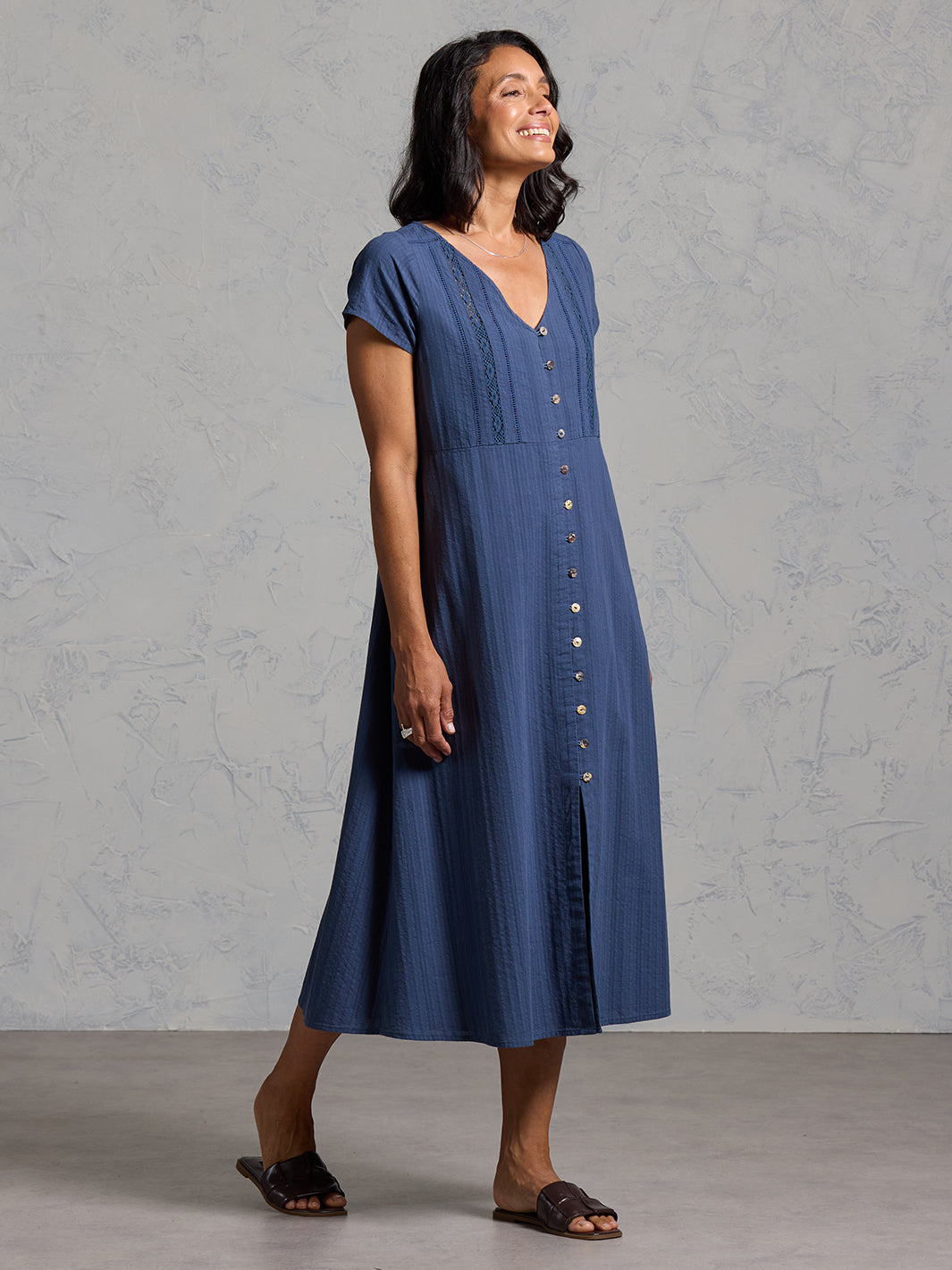 A woman wearing a cotton dress in navy from Nomad the Label