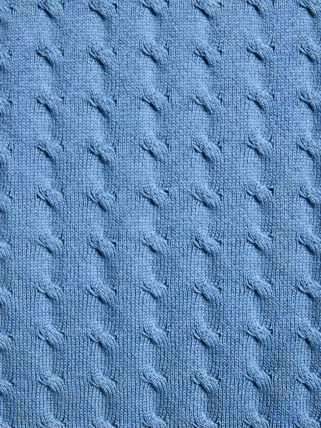 Close-up of blue textured fabric with cable knit pattern