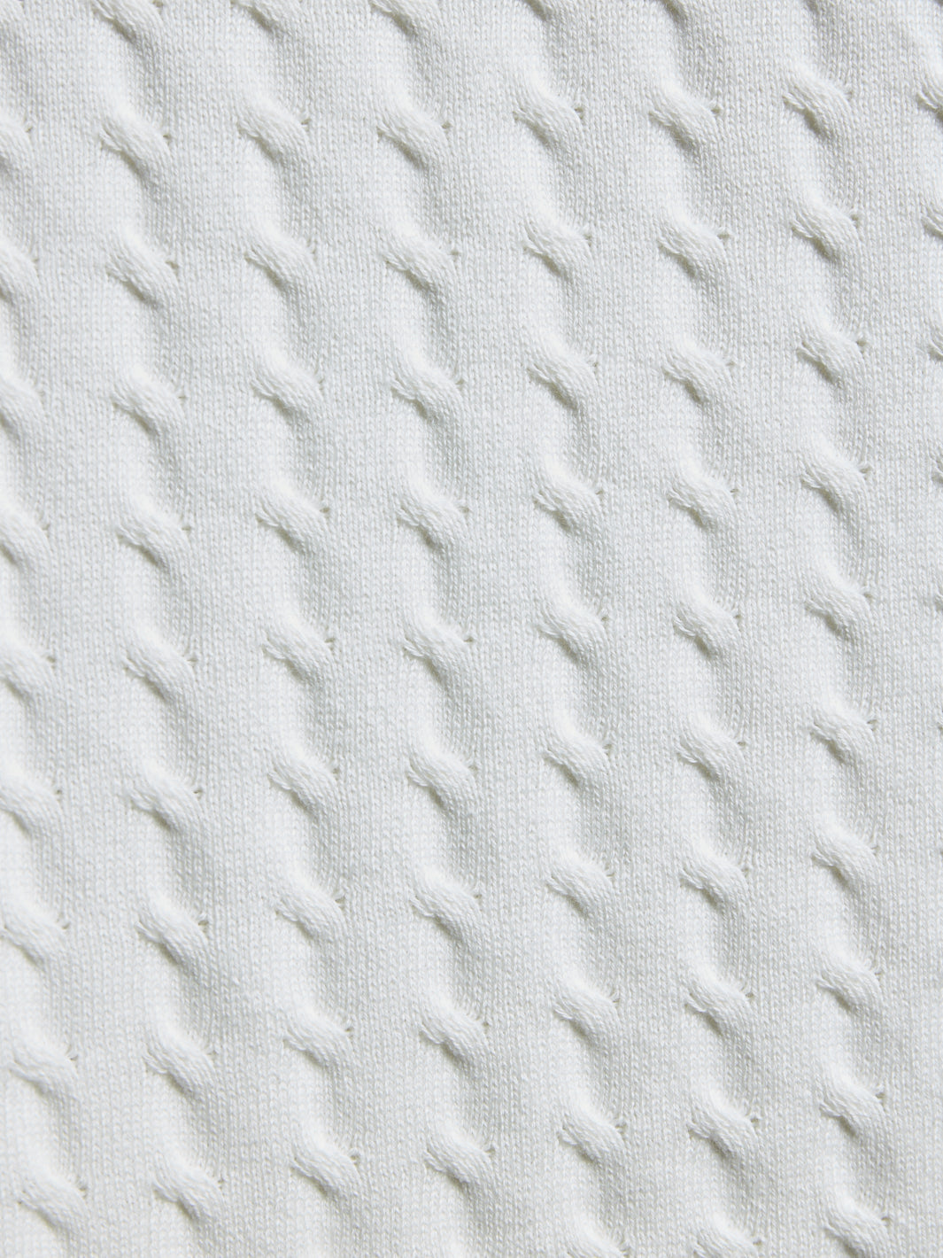 Close-up of textured light gray fabric with diagonal stitching pattern