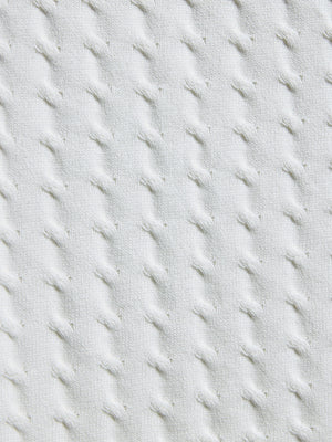 Close-up of textured light gray fabric with diagonal stitching pattern