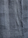 Close-up of a textured gray fabric with frayed edges