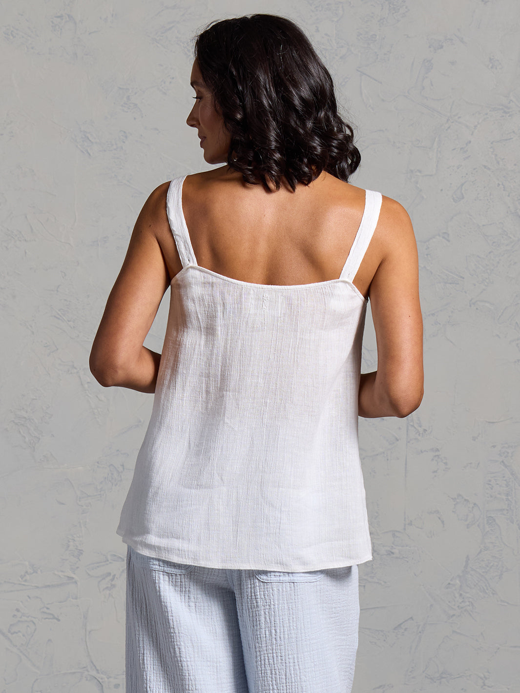 A woman wearing a coconut linen top from Nomad the Label