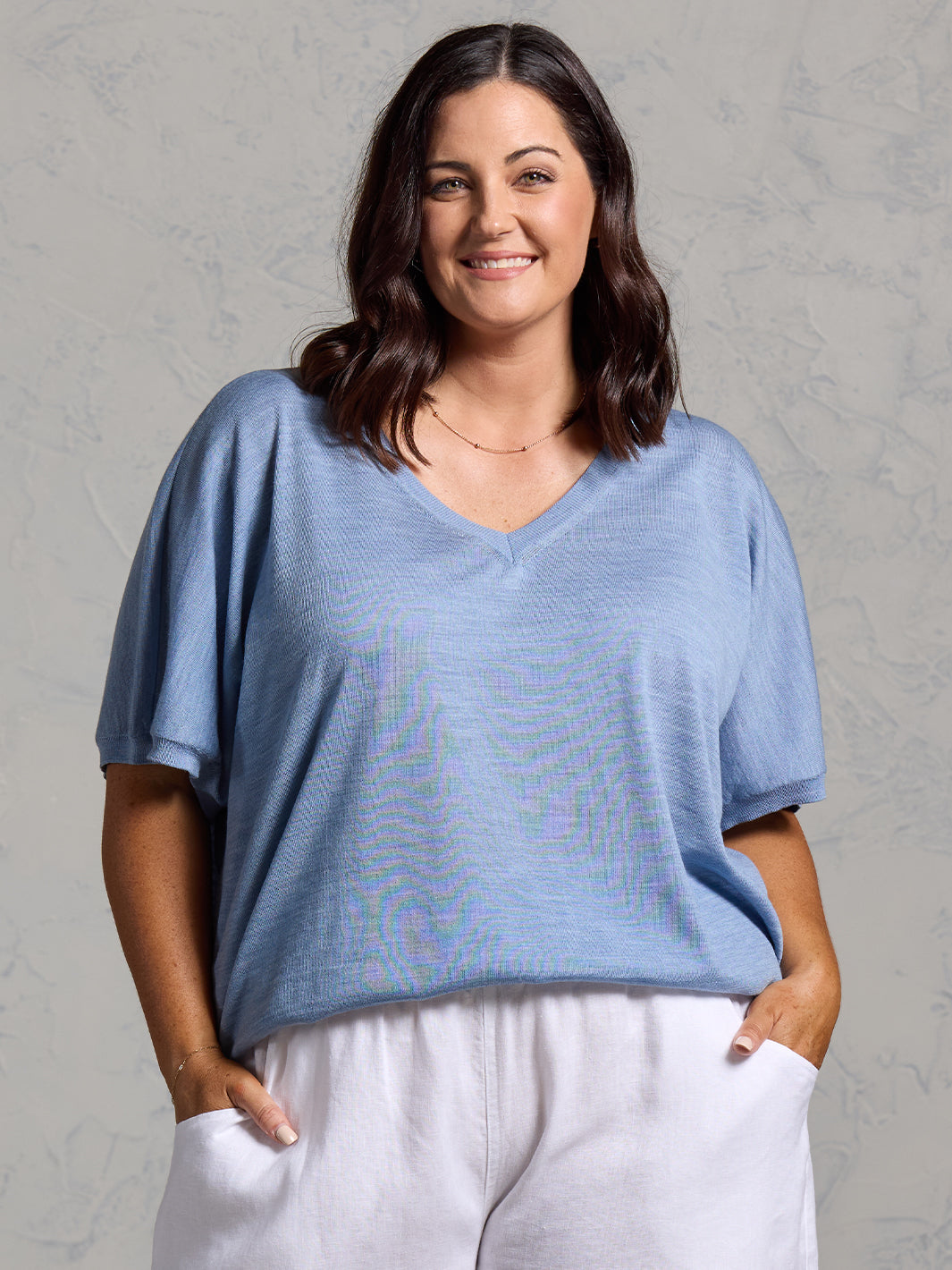 A woman wearing Toscana Merino Wool Top Sea Blue and Sadhu French Linen Pants White