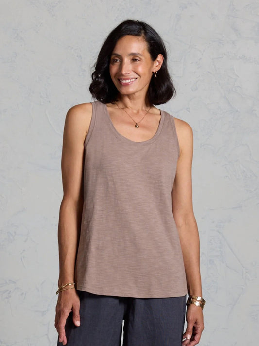 Woman wearing a brown tank top against a gray background