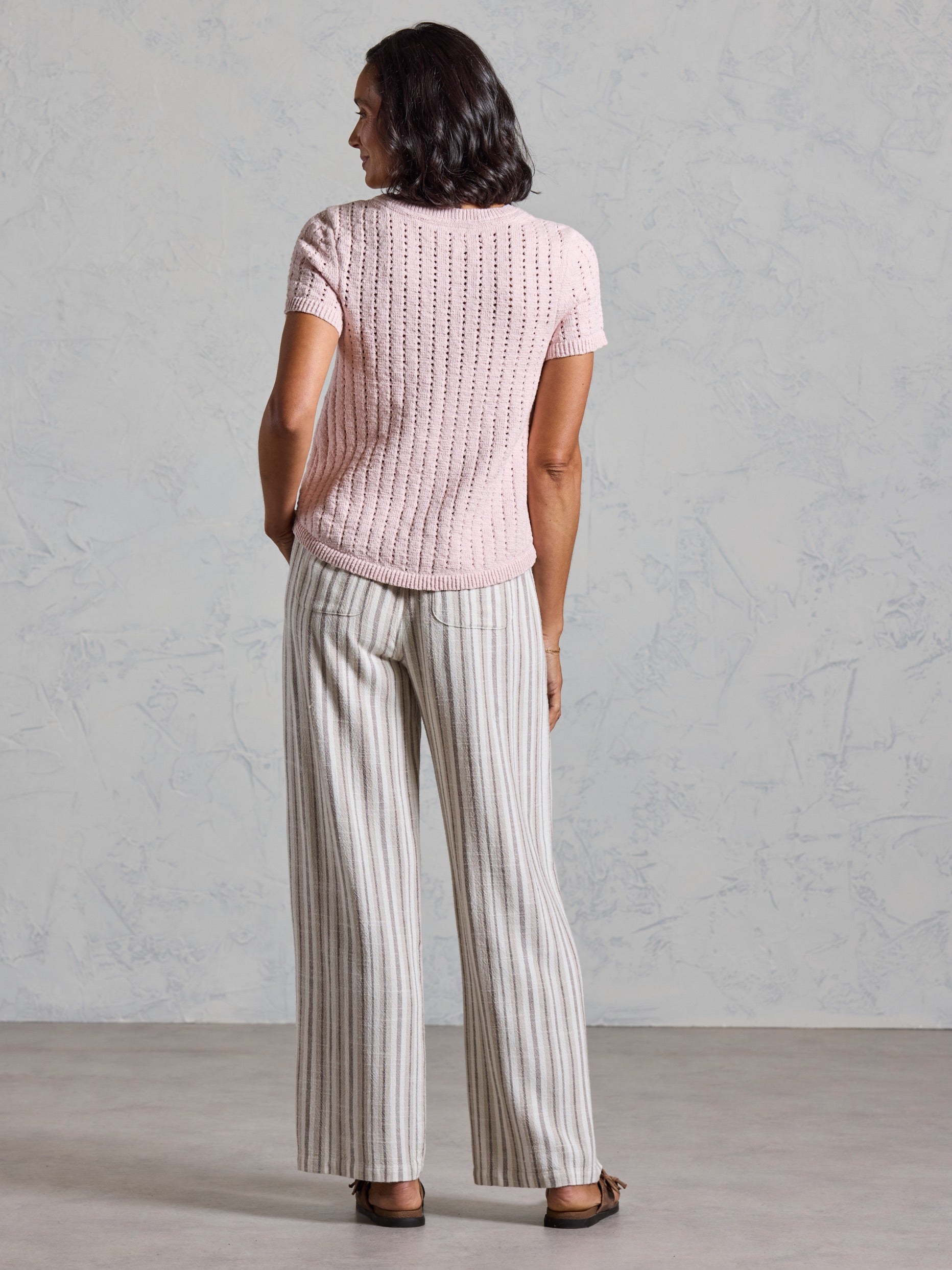Back view of the Agni Cotton Linen Knit Top in rosewater showing the textured pointelle knit and ribbed hem.