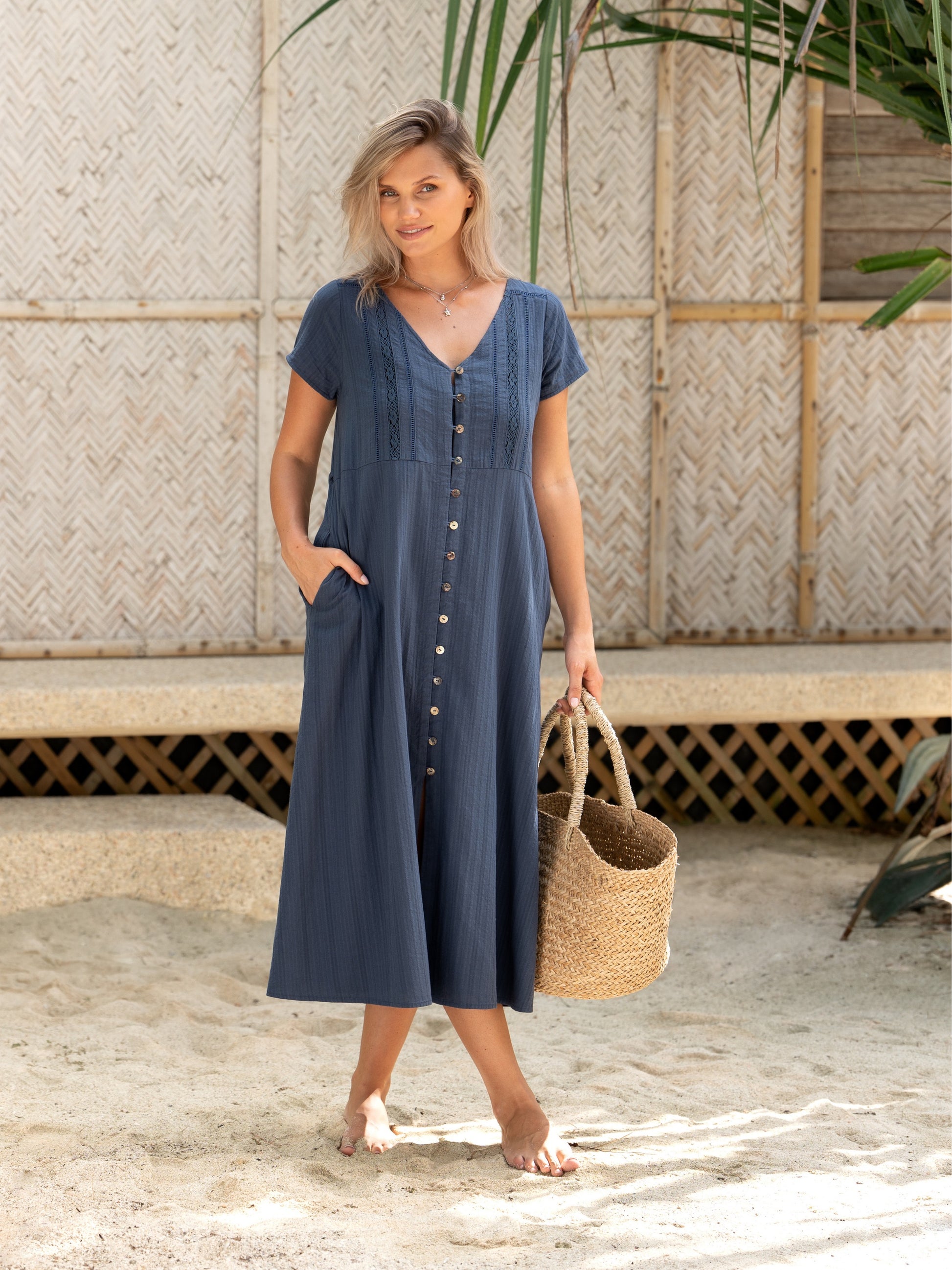 A woman wearing a cotton dress in navy from Nomad the Label