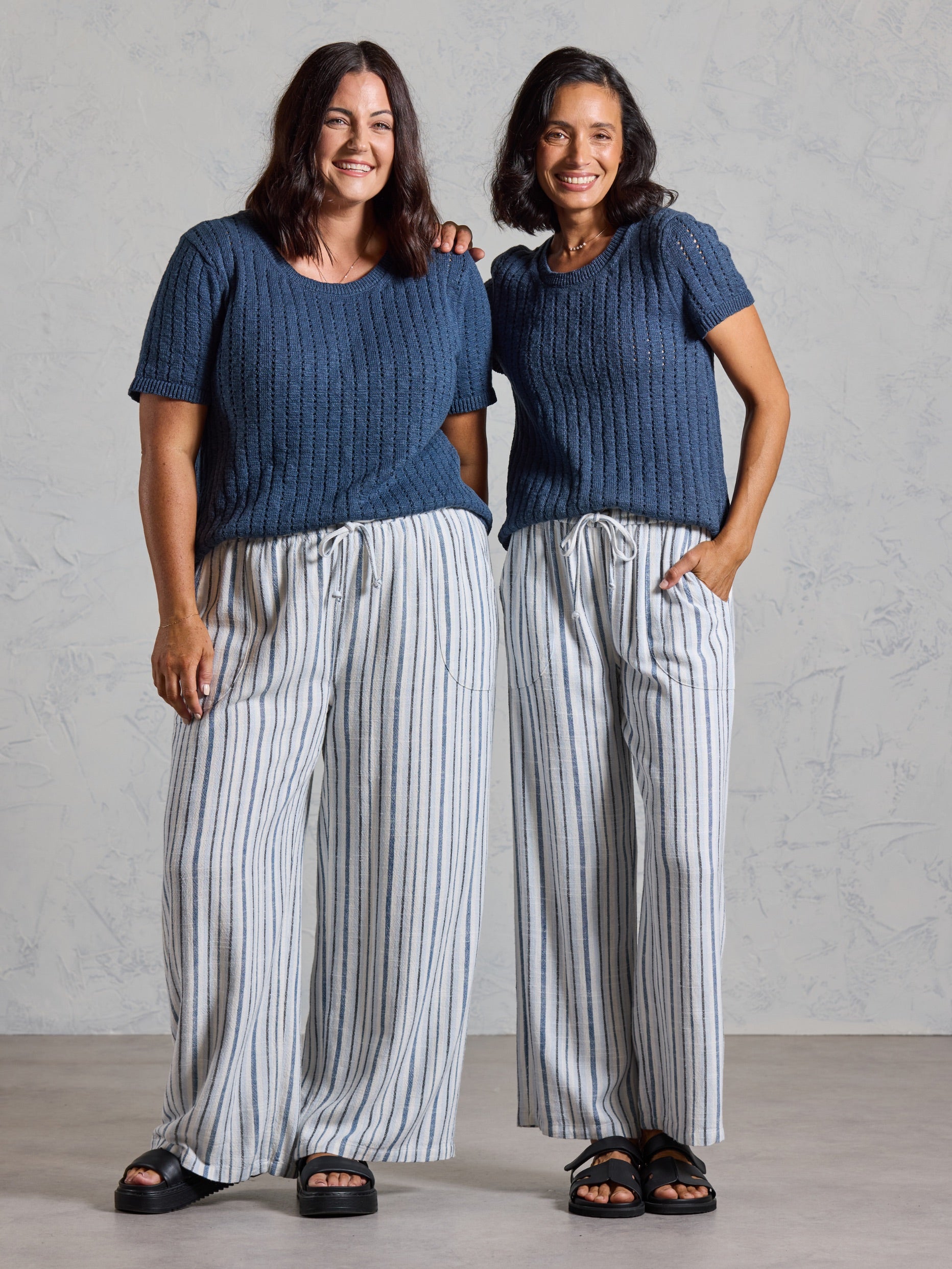 Two models wearing the Jolie Linen Blend Trousers in coastal blue with navy knit tops