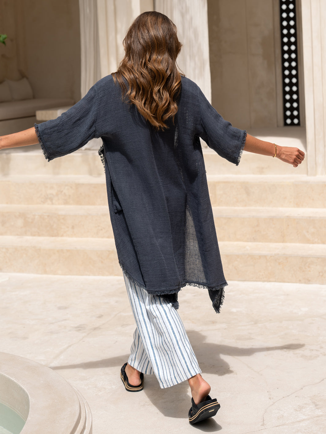 Back view of the Laguna French Linen Kimono in charcoal, showing the draped silhouette in motion.