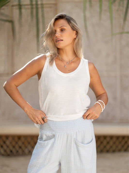 A woman wearing Sur Mer Organic Cotton Trousers Serene Blue and Yarra Cotton Top Coconut from Nomad the Label