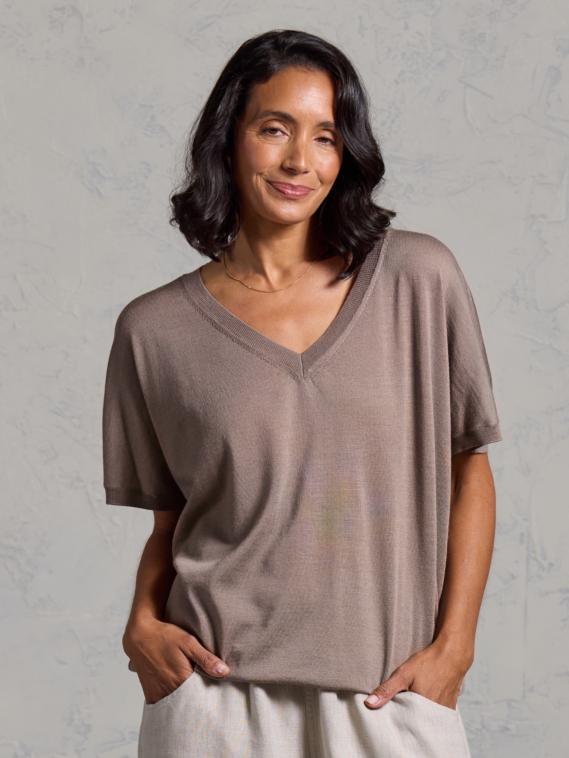 A woman wearing Toscana Merino Wool Top Elm and Sadhu French Linen Pants Flax